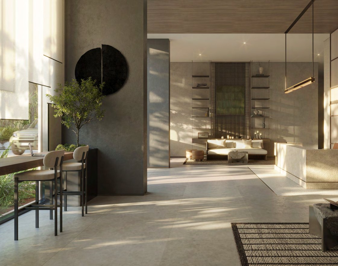 Sunlit stone lobby with a reception desk, sofa and tall windows