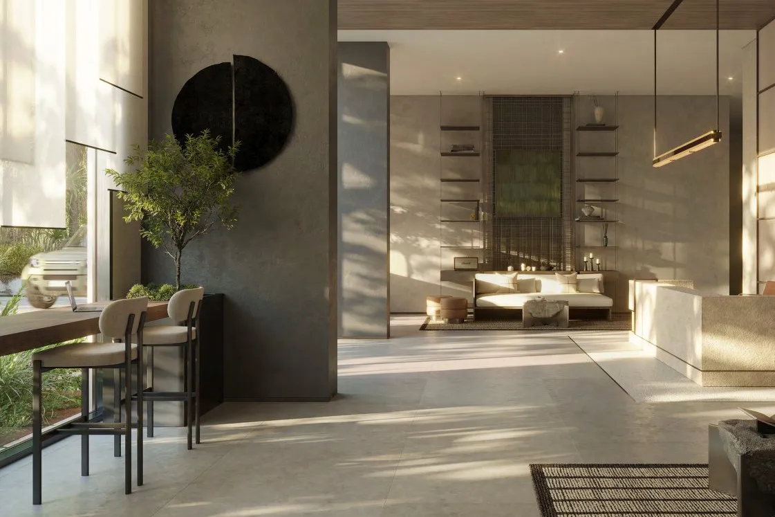 Sunlit stone lobby with a reception desk, sofa and tall windows