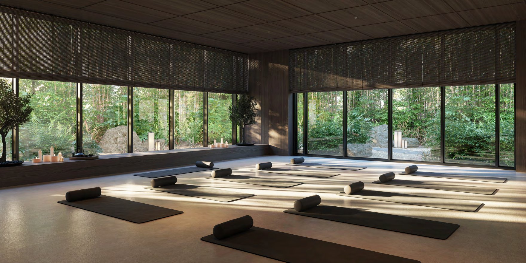 Yoga studio with mats laid out and floor-to-ceiling windows onto bamboo garden