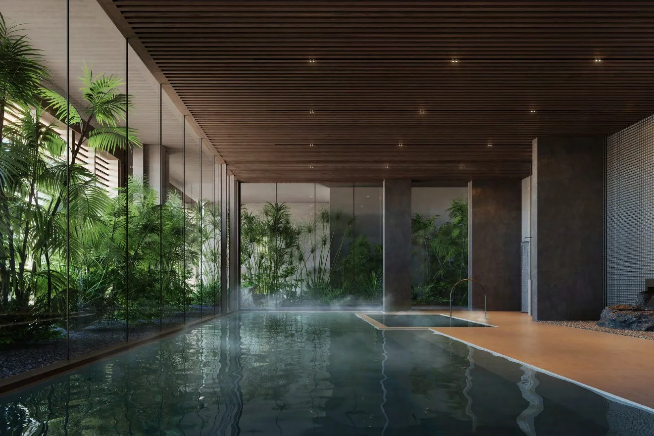 Indoor hot and cold baths beside a glass wall of tropical planting