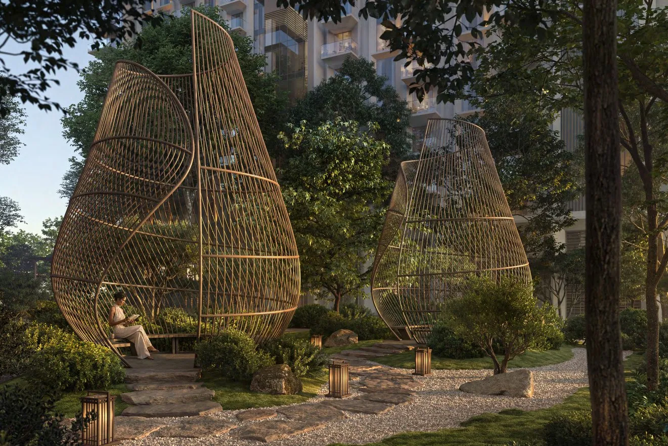 Woven pod sculptures with seating along a stone path in the garden